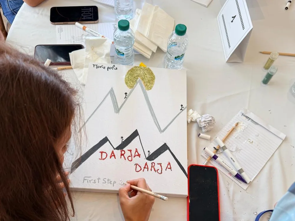 Une équipe peint sur toile l'affiche « Darja Darja » pour la cérémonie de remise de prix.